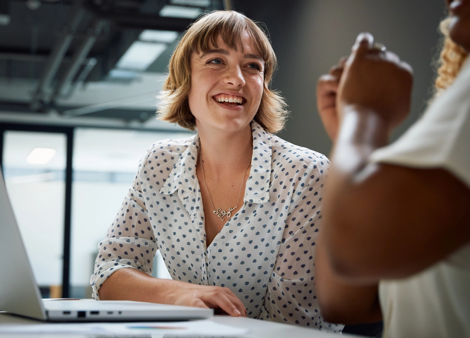 Woman smiling in front of a laptop